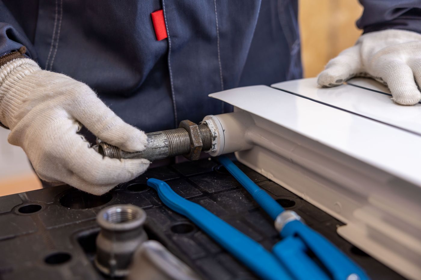 Monteur sluit een leiding aan op een radiator